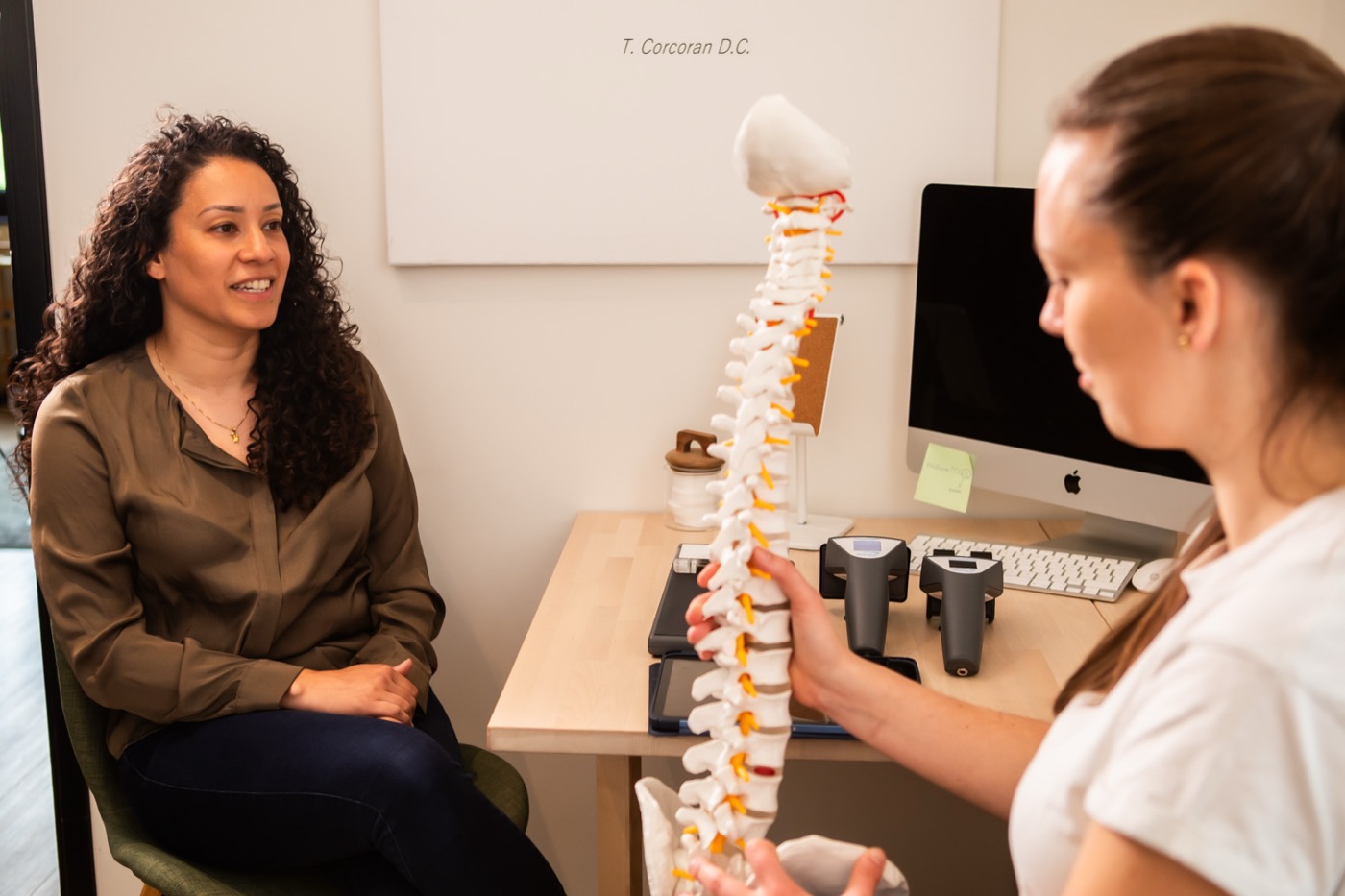 Chiropractor legt met een wervelkolommodel uit wat de scan laat zien bij TOPCHIRO Almere
